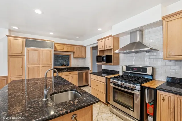 a kitchen with granite countertop a stove sink and cabinets
