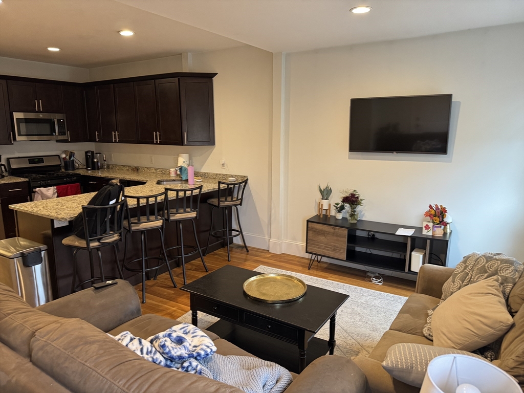 28 Howell Street, Unit 3 Boston, MA 02125 - Photo 5 of 11 a living room with furniture kitchen and a flat screen tv