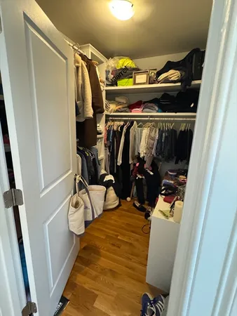 a view of walk in closet with clothes and shoes