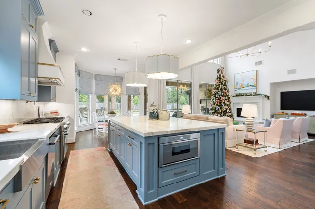 a view of a white house with a small yard and wooden fence