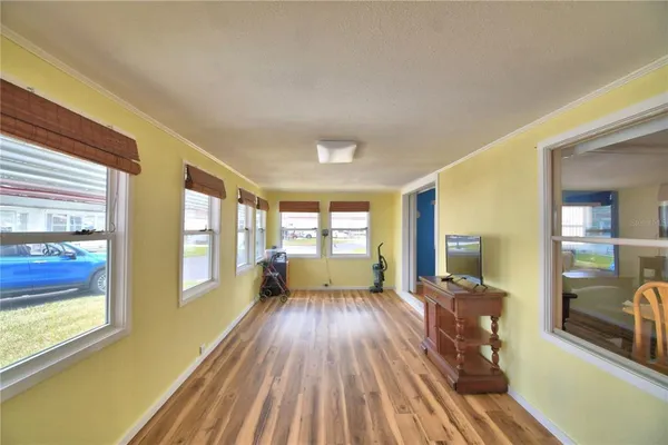 a view of a living room with a large window wooden floor and furniture
