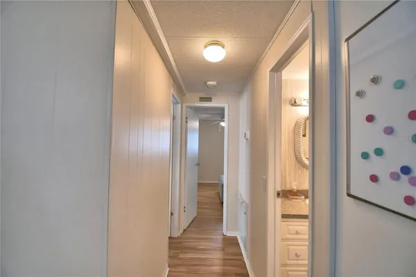 a view of a hallway with wooden floor and closet