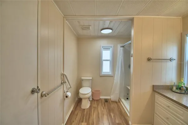 a bathroom with a granite countertop sink a toilet and shower