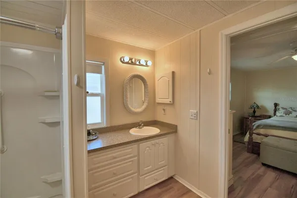 a en suite bathroom with a granite countertop sink mirror and vanity