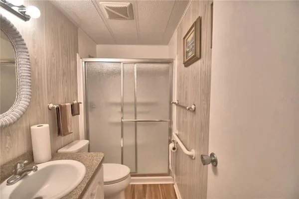 a bathroom with a granite countertop sink toilet and shower