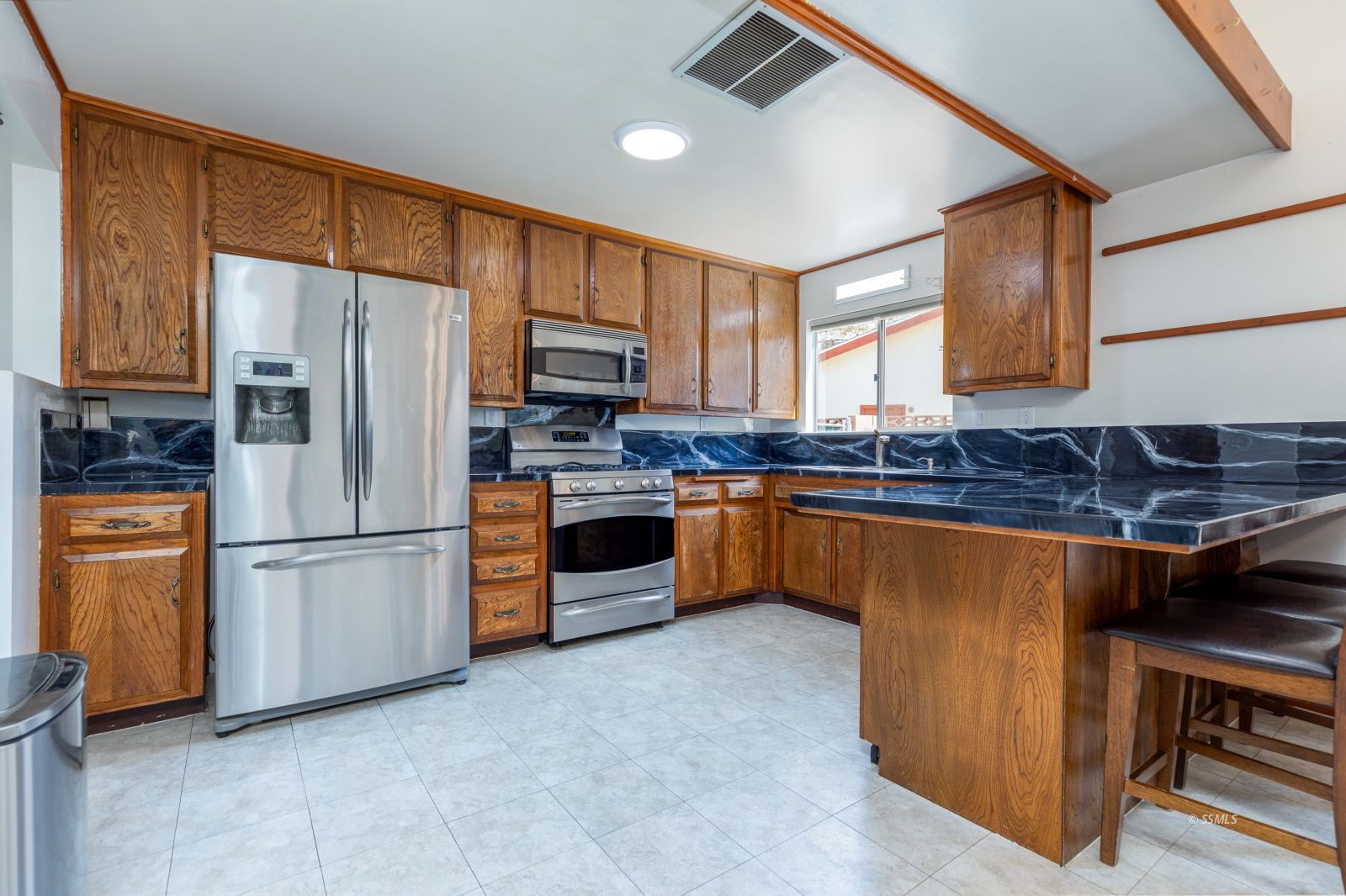 300 Mari Court Ridgecrest, CA 93555 - Photo 10 of 33 a kitchen with stainless steel appliances granite countertop a refrigerator a stove a sink a microwave and cabinets