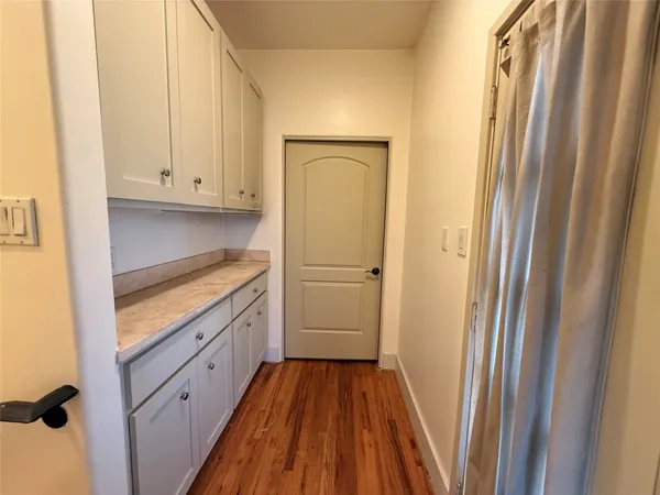 a kitchen with white cabinets and refrigerator