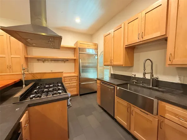 a kitchen with stainless steel appliances a sink stove and refrigerator