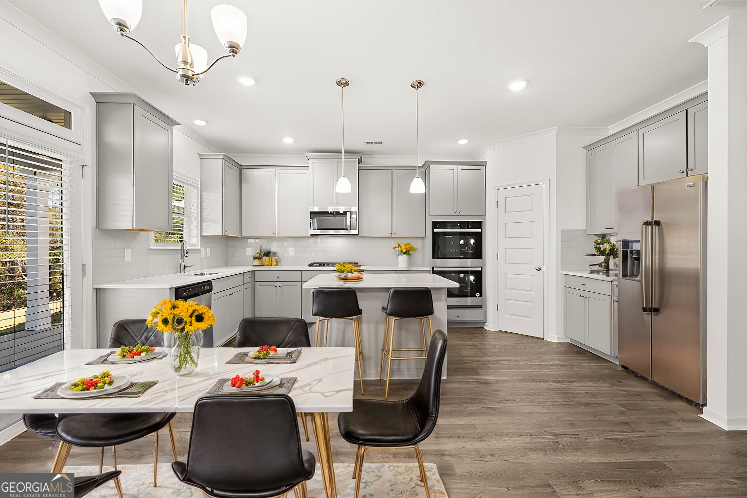 1776 Goodwin Drive Hampton, GA 30228 - Photo 9 of 59 a kitchen with stainless steel appliances kitchen island granite countertop a dining table chairs refrigerator and sink