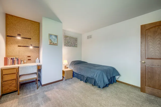 a bedroom with a bed and a painting on the wall