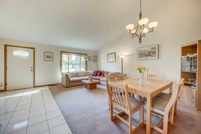 a view of a dining room with furniture and chandelier