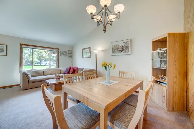 a view of a dining room with furniture a chandelier and wooden floor