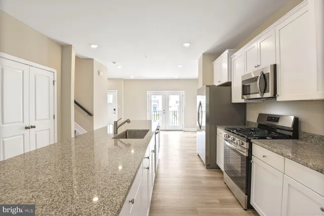 a kitchen with stainless steel appliances granite countertop a stove a sink and a microwave