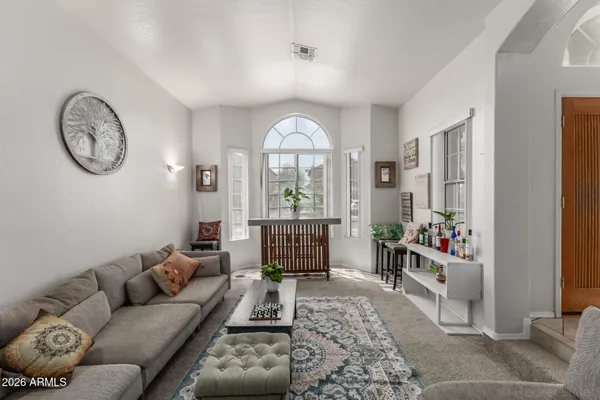a living room with furniture a clock and a large window