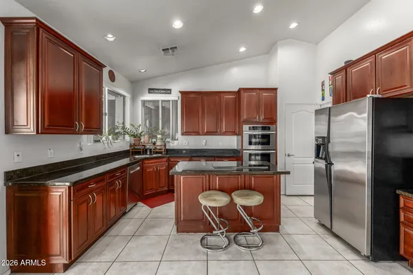 a kitchen with stainless steel appliances granite countertop a refrigerator and a stove top oven
