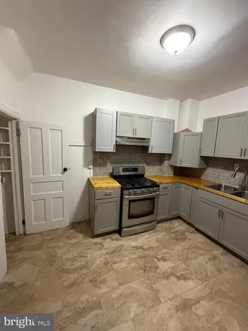 a kitchen with granite countertop a stove and cabinets