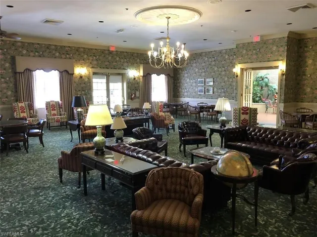 a living room with furniture a chandelier and a dining table