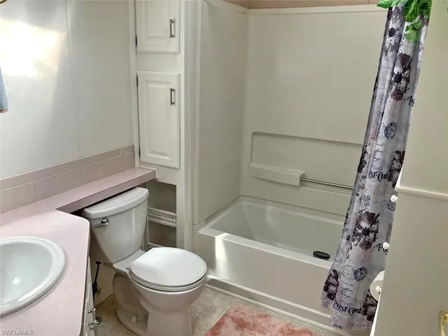 a white toilet sitting next to a bath tub