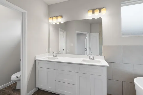 a white toilet next to a bathroom