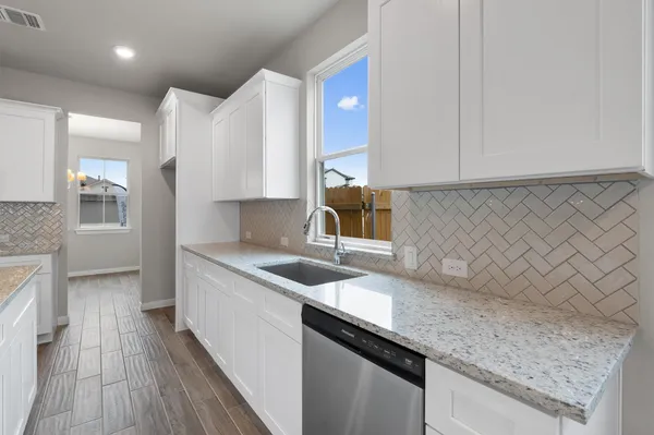 a view of an empty room with a chandelier fan