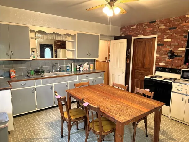 a kitchen with stainless steel appliances kitchen island granite countertop a table chairs and a refrigerator