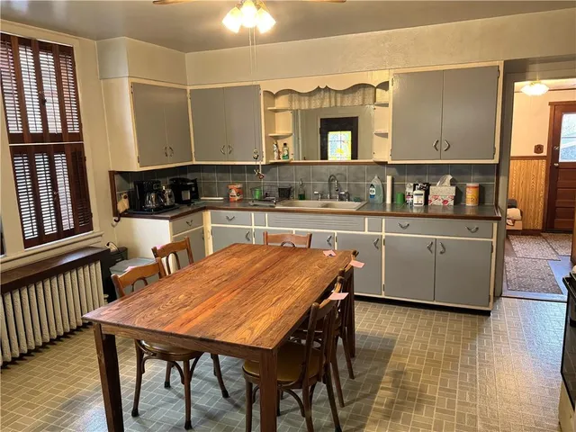 a kitchen with stainless steel appliances granite countertop a table chairs sink and cabinets