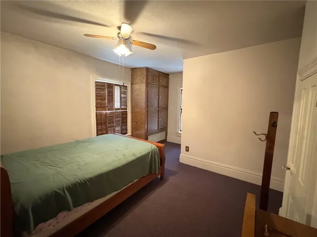 a room with a bed and a ceiling fan