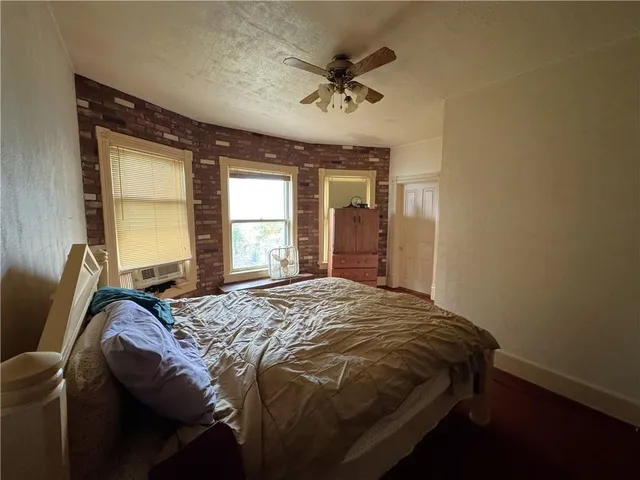 a bed sitting in a spacious bedroom next to a window