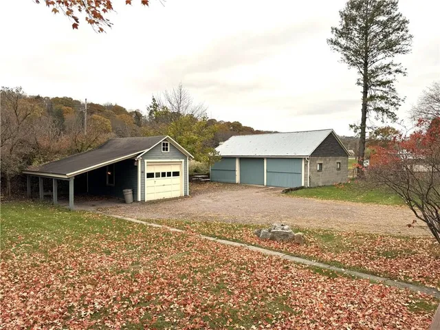 a view of a house with a yard and large tree