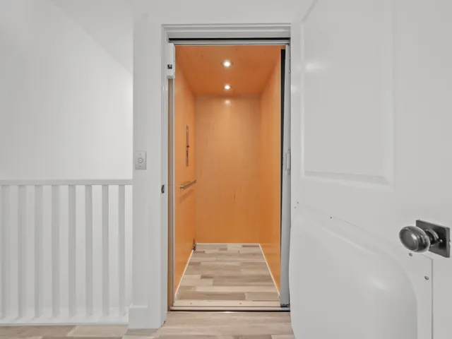 a view of a hallway with wooden floor and a door
