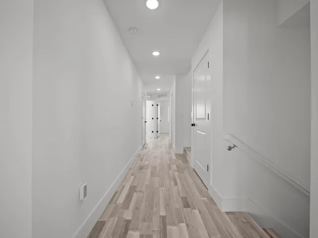 a view of a hallway with wooden floor