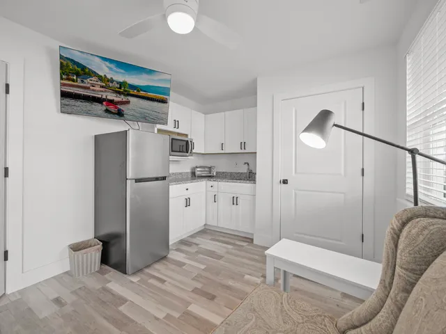 a kitchen with white cabinets and refrigerator