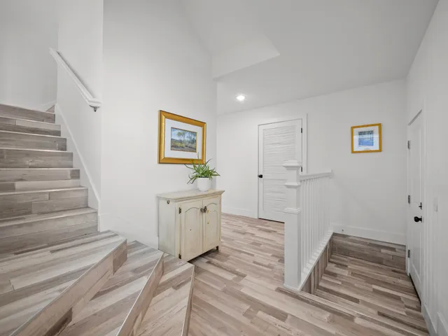 a view of a hallway with wooden floor and stairs