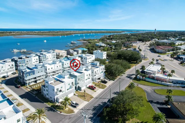 an aerial view of a city with lots of residential buildings and ocean view in back
