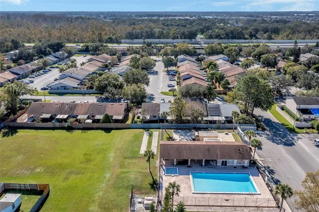 an aerial view of a house with swimming pool and lake view