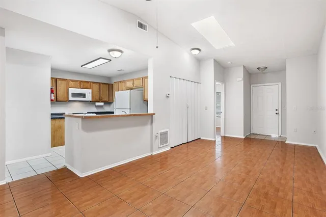 a view of kitchen with granite countertop cabinets and window