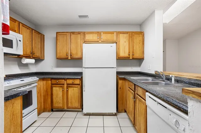 a kitchen with stainless steel appliances granite countertop a refrigerator sink stove and granite counter top