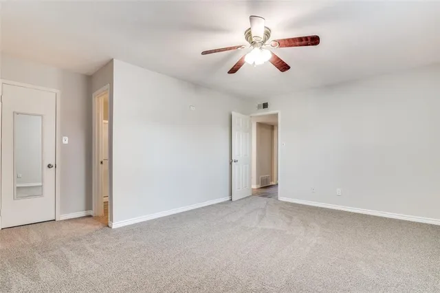 a view of an empty room with a ceiling fan