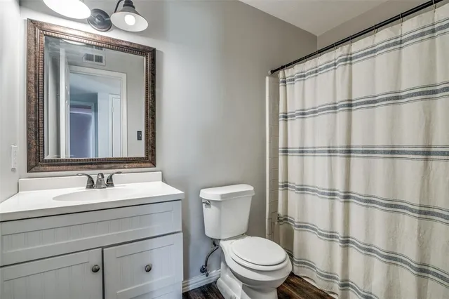 a bathroom with a granite countertop sink mirror vanity and toilet