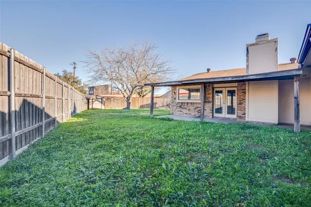 a view of a house with backyard and a tree