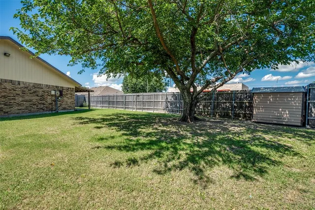 a view of a house with backyard and a tree