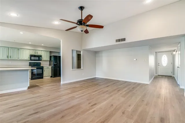 a view of empty room with wooden floor and window