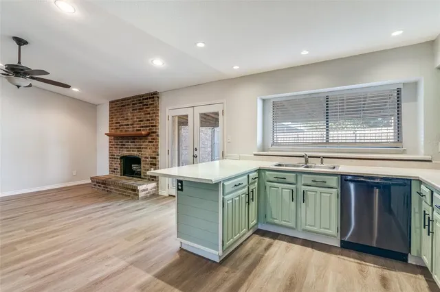 a kitchen with kitchen island a sink dishwasher a stove and a wooden cabinets with wooden floor