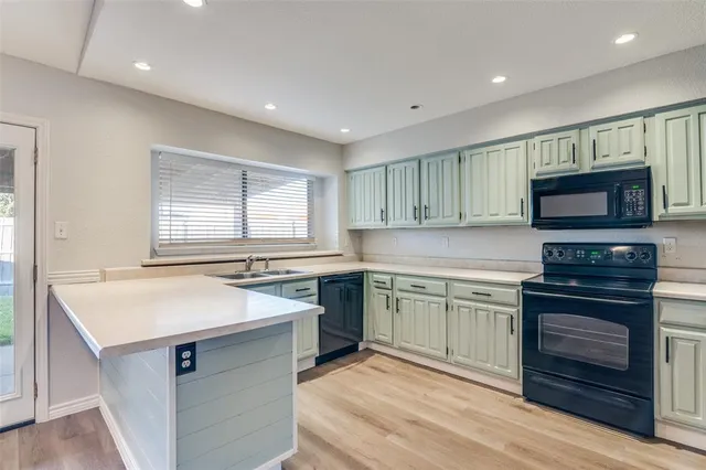 a kitchen with kitchen island granite countertop a stove sink and microwave
