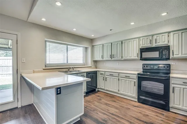 a kitchen with a sink stove top oven and cabinets