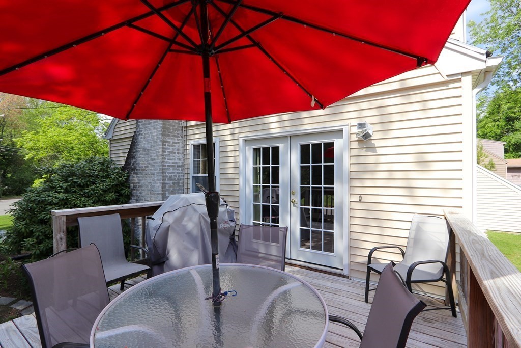 26 Elda Road Framingham, MA 01701 - Photo 24 of 27 a patio with a table and chairs under an umbrella