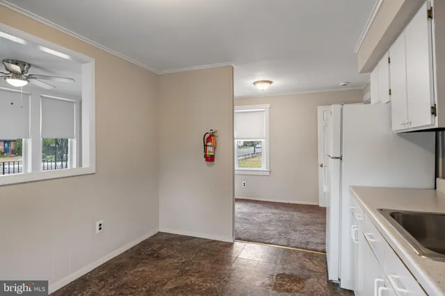 a view of kitchen with a sink refrigerator and window