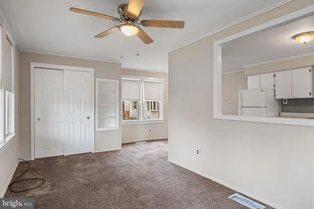 a view of empty room with window and ceiling fan