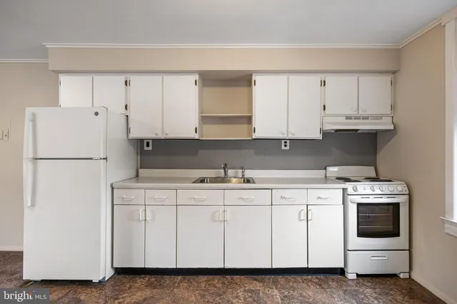a kitchen with white cabinets and white appliances