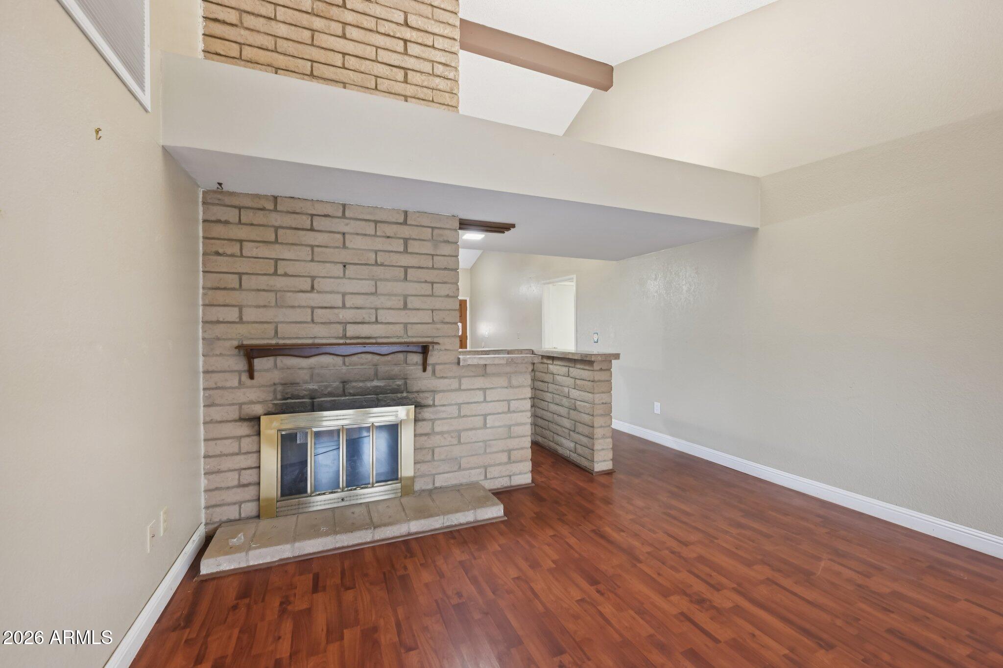 2201 West Utopia Road Phoenix, AZ 85027 - Photo 13 of 50 a view of an empty room with wooden floor fireplace and a window